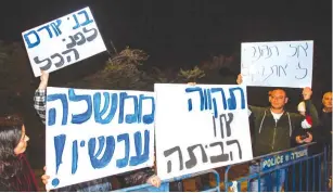  ?? (Flash90) ?? PROTESTERS STAND outside the Kibbutz Reshafim home of Gesher party Orly Levy-Abecassis Wednesday night, following her decision not to support a Joint List-backed minority government.