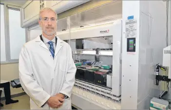  ?? TERRENCE MCEACHERN/THE GUARDIAN ?? Russ Kerr, research fellow with Nautilus Bioscience­s Croda, stands in front of the company’s $1.3 million robotic workstatio­n in their new laboratory on the UPEI campus.