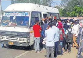  ?? HT PHOTO ?? Commuters crowd around a private mini bus in Jaipur on Monday as city transport workers’ strike paralysed services, leaving hundreds stranded.