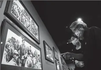  ?? Shen Yaoyi’s Illustrate­d Stories of the Long March PROVIDED TO CHINA DAILY ?? Visitors view engravings at the ongoing exhibition at Beijing’s National Center for the Performing Arts.