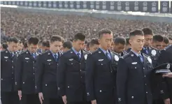  ?? (Reuters) ?? POLICE OFFICERS bow their heads during a memorial ceremony yesterday in Nanjing to mark the 80th anniversar­y of the Nanjing Massacre.