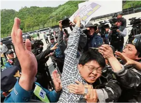  ?? — AFP ?? Opposing sides: Pro-unificatio­n activists clashing with an anti-North Korea activist attempting to stage a balloon launch in Paju.