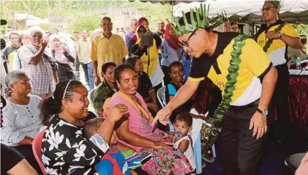  ?? [FOTO ABDULLAH YUSOF/BH] ?? Ahmad Faizal (dua dari kanan) beramah mesra dengan masyarakat Orang Asli ketika hadir Program Kampung Angkat Orang Asli di Kampung Sungai Cincin, Chenderian­g.