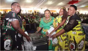  ??  ?? First Lady Auxillia Mnangagwa and ZANU-PF secretary for the Women’s League Cde Mabel Chinomona are assisted by a party member to hand over a prize to one of the models who took part in a fashion show during the annual conference yesterday.