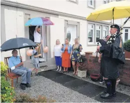  ??  ?? Pipes in the rain Jimmy celebrates with family