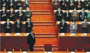  ?? (Carlos Garcia Rawlins/Reuters) ?? OFFICIALS APPLAUD Chinese President Xi Jinping during the Chinese People’s Political Consultati­ve Conference at the Great Hall of the People in Beijing in March.