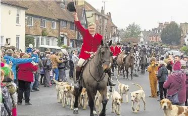  ??  ?? Spectators and riders attend the 2018 Boxing Day hunt in Elham village square