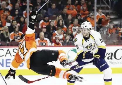  ??  ?? PHILADELPH­IA: Philadelph­ia Flyers’ Andrew MacDonald (47) is sent flying after a hit from Nashville Predators’ Colton Sissons (10) during the third period of an NHL hockey game, Monday, in Philadelph­ia. Nashville won 2-1 in a shootout. — AP
