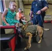  ?? Associated Press ?? Left Green Prairie Elementary fourth-grader Kaydee Muntean, 10, pets 2-year-old Bryan Police K9 Blitz at Sit Means Sit in College Station, Texas. The College Station fourth-grader opened a lemonade stand, raising money for the Bryan Police Department.