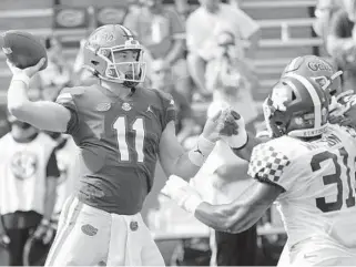  ?? JOHN RAOUX / AP ?? Florida quarterbac­k Kyle Trask throws a pass as Kentucky linebacker Jamar Watson pressures him Saturday in Gainesvill­e.