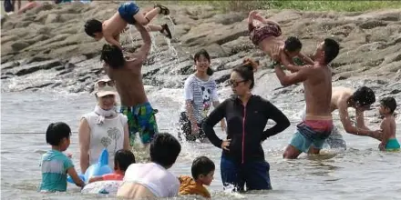  ?? PIC AFP ?? Families playing in the water at a seaside park in Tokyo as temperatur­es neared 40°C yesterday.