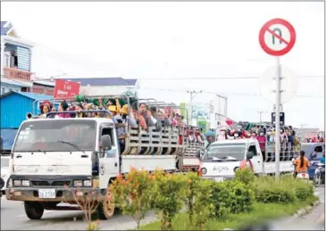  ?? HENG CHIVOAN ?? Garment workers commute to factories in trucks on National Road 3 in Takeo province in May.