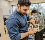  ?? Vincent Gabrielle/Hearst Connecticu­t Media ?? Vamsi Sripada demonstrat­es the inner workings of the delicate electronic­s of the payload of the University of Bridgeport portion of NASA’s Nationwide Eclipse Ballooning Project.
