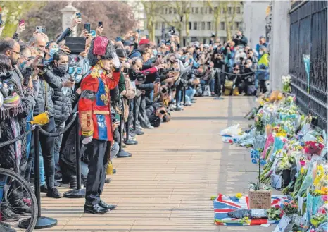  ?? FOTO: IAN WEST/DPA ?? Ein Mann, verkleidet als Grenadier Guard, salutiert vor dem Buckingham-Palast, wo viele Menschen Blumen für Prinz Philip niedergele­gt haben.