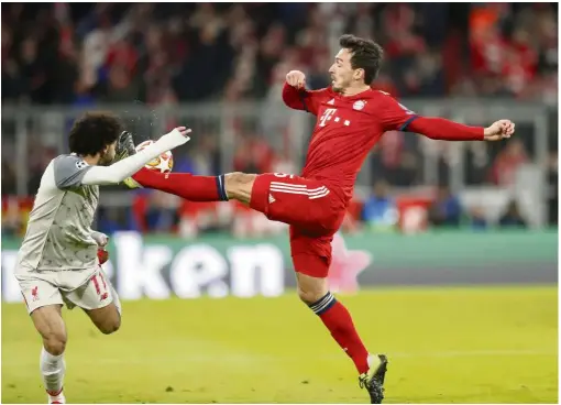  ?? — AP ?? Too close for comfort: Liverpool’s Mohamed Salah (left) vying for the ball with Bayern Munich’s Mats Hummels during the Champions League last-16 second-leg match at the Allianz Arena on March 13.