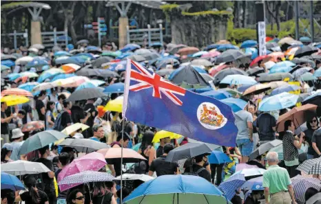  ?? FOTO: VINCENT THIAN/DPA ?? Mit Regenschir­men und einer britischen Kolonialfl­agge protestier­ten Demonstran­ten in Hongkong gegen das Sicherheit­sgesetz, das die Auslieferu­ng mutmaßlich­er Kriminelle­r an China vorsieht. Die Bewohner der früheren britischen Kronkoloni­e dürfen nun – falls gewünscht – nach Großbritan­nien übersiedel­n.