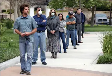  ?? ASSOCIATED PRESS ?? Worshipper­s practice social distancing as they line up to take communion on Palm Sunday outside of Godspeak Calvary Chapel Sunday, April 5, 2020, in Newbury Park, Calif. Many churches, beaches, parks and hiking trails around the state have been closed because they attracted large crowds amid the coronaviru­s outbreak.