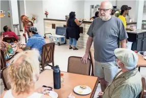  ??  ?? Mac Edwards, the new executive director of Caritas Village, center, talks with guests during their grand re-opening party on Aug. 25. The cafe opened for lunch on Wednesday. BRAD VEST/THE COMMERCIAL APPEAL,