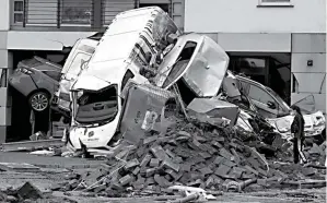  ?? CHRISTOF STACHE/AFP ?? RUSAK PARAH: Seorang warga melihat tumpukan mobil dan puing-puing di jalan setelah banjir mengakibat­kan kerusakan besar di Bad Neuenahr-Ahrweiler, Jerman, pada Jumat (16/7).