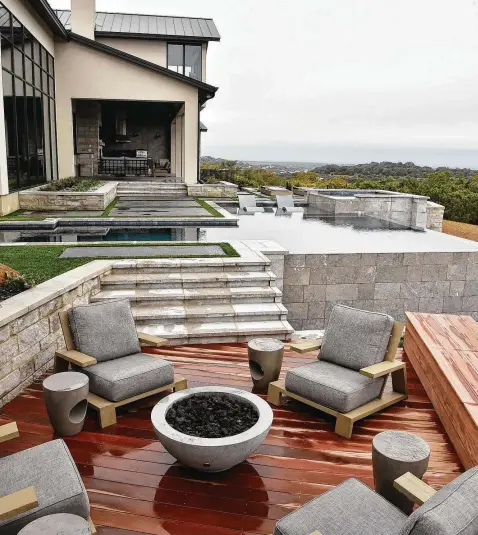  ?? Photos by Robin Jerstad / Contributo­r ?? An outdoor seating area on an ipe hardwood deck. The covered patio, in background, includes a seating area and a well-appointed kitchen.