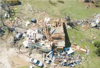  ?? JAIME GREEN/THE WICHITA EAGLE ?? Tornado’s wrath: A home destroyed by a tornado is seen Saturday in Andover, Kansas. Officials said the twister hit southeast Wichita and Andover on Friday evening. They also said several people were injured and thousands were left without power. Andover Fire Chief Chad Russell said 50 to 100 buildings were damaged in Sedgwick County.