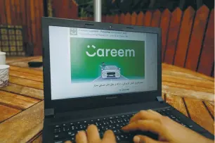  ?? (Mohamad Torokman/Reuters) ?? AN EMPLOYEE shows an advertisem­ent for ride-hailing company Careem in his Ramallah office on Monday. Careem launched in 2012 and now operates in 12 countries and more than 80 cities across the Middle East, Africa and South Asia.