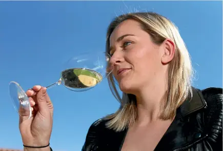  ?? PHOTO: SCOTT HAMMOND/STUFF ?? Wine Marlboroug­h marketing and communicat­ions co-ordinator Harriet Wadworth with one of the new Veritas Sauvignon Blanc glasses.