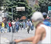  ?? AP PHOTO ?? Pro-government supporters confront anti-government protesters in Caracas, Venezuela, Thursday.