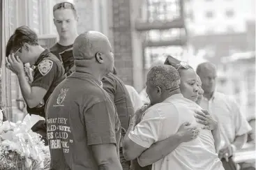  ?? Mary Altaffer / Associated Press ?? Police officers and their co-workers react following a prayer service outside the 46th Precinct in the Bronx borough of New York Wednesday. A police officer from the 46th Precinct was shot to death early Wednesday.
