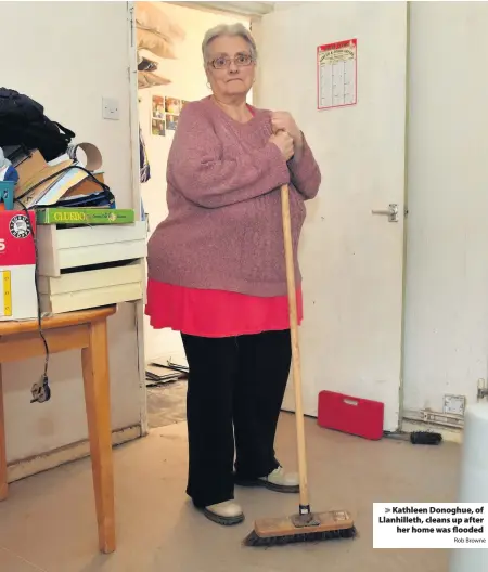  ?? Rob Browne ?? > Kathleen Donoghue, of Llanhillet­h, cleans up after her home was flooded