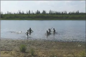  ?? The Associated Press ?? ARCTIC: In this handout photo provided by Olga Burtseva, children play in the Krugloe lake outside Verkhoyans­k, the Sakha Republic, about 4660 kilometers (2900 miles) northeast of Moscow, Russia, Sunday.