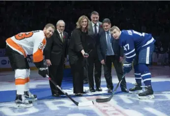  ?? RICK MADONIK/TORONTO STAR ?? Flyers centre Claude Giroux, left, and the Leafs’ Leo Komarov, join Rogie Vachon, Kalli Quinn, representi­ng her father Pat, Eric Lindros and Sergei Makarov for the start of Hall of Fame weekend before Friday’s game.