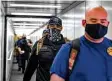  ??  ?? Canyon Lake firefighte­r Carl Ballard and others traverse a passageway as they head for the charter flight to California.