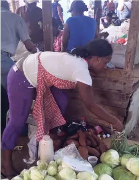  ?? PHOTOS BY RUDDY MATHISON ?? Jody Ann Pottinger packaging string beans from a small pile that includes cabbage and sweet potatoes.