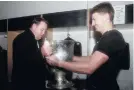  ?? PHOTO: GETTY IMAGES ?? Beauden Barrett hands the Bledisloe Cup to Steve Hansen in the Eden Park changing rooms on Saturday night.