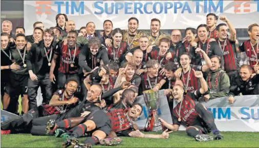  ??  ?? CELEBRACIÓ­N. La plantilla del Milán al completo festeja su título sobre el césped del estadio de Doha.