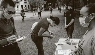  ?? Tamir Kalifa / For the Washington Post ?? Texas State University students register to vote. Campuses hit by the pandemic have seen a lack of organized voter drives; new rules and changing guidelines are jeopardizi­ng their votes.