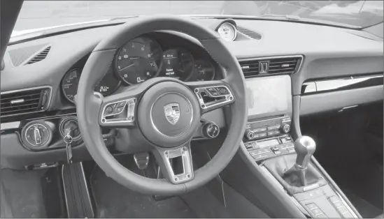  ??  ?? The interior of the 2018 Carrera T is classic 911 all the way with five-pot main gauge cluster. Note the Porsche design cue ignition key to the left of the steering wheel.