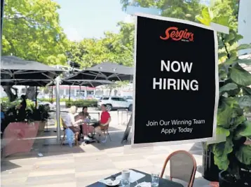  ?? SUSAN STOCKER/SOUTH FLORIDA SUN SENTINEL ?? Hiring signs are posted on windows at Sergio’s Cuban Cafe & Grill on Coral Way in Miami on Thursday. Sergio’s only has outdoor seating because it can’t find enough workers to open fully.