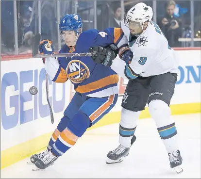  ?? SETH WENIG — THE ASSOCIATED PRESS ?? The Sharks’ Evander Kane right, battles the Islanders’ Thomas Hickey for the puck during San Jose’s loss on Monday in New York.
