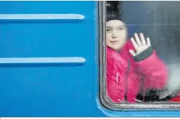  ?? MANUEL BRUQUE / EFE ?? Un niño se despide de un familiar montado en un tren que parte de Odesa.