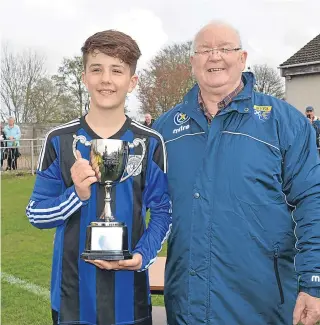  ??  ?? Forfar Boys U/13s captain Rowan Waddell receives the Diamond Jubilee Cup from DDYFA Vice-President Colin (Chippy) Lowe after the triumph over Ferry.