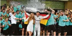  ?? Foto: afp ?? Feuchtfröh­licher Zieleinlau­f: der Weltmeiste­r, seine Frau Vivien und das Mercedes Team in Abu Dhabi.