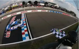  ?? (Sean Gardner/getty Images) ?? Kyle Larson, driver of the #5 Hendrickca­rs.com Chevrolet, takes the checkered flag to win the Cup Series Go Bowling at The Glen at Watkins Glen Internatio­nal Sunday.