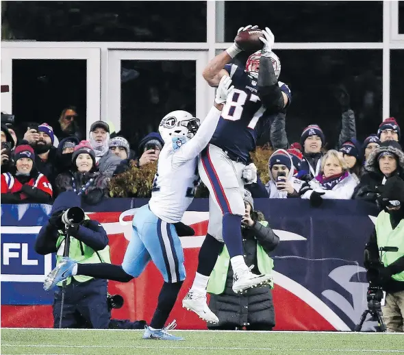  ?? — GETTY IMAGES ?? New England Patriots tight end Rob Gronkowski catches a touchdown pass while being defended by Kevin Byard of the Tennessee Titans Saturday during the Patriots’ 35-14 AFC divisional round playoff win at Gillette Stadium in Foxborough, Mass.