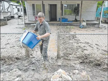  ?? Timothy D. Easley
The Associated Press ?? Members of the local Mennonite community remove mud-filled debris from homes following flooding at Ogden Hollar in Hindman, Ky., on Saturday.