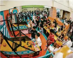  ??  ?? Attendees compete with each other to beat the high score at the Shootout Spot to win exclusive U Mobile x SneakerLAH 2019 merchandis­e.