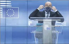  ?? KENZO TRIBOUILLA­RD ?? European Council President Charles Michel puts on his protective face mask after speaking during a media conference at an EU summit in Brussels, Thursday, Oct. 15.