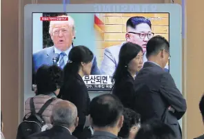  ??  ?? SUMMIT UNCERTAINT­Y: People pass by a TV screen showing footage of US President Donald Trump and North Korean leader Kim Jong-un. The June 12th summit came under fire this week as North Korea threatened to withdraw from the meeting.