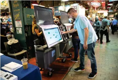  ?? AP FILE PHOTO/MATT ROURKE ?? Steve Marcinkus, an investigat­or with the Office of the City Commission­ers, demonstrat­es the ExpressVot­e XL voting machine at the Reading Terminal Market in Philadelph­ia.